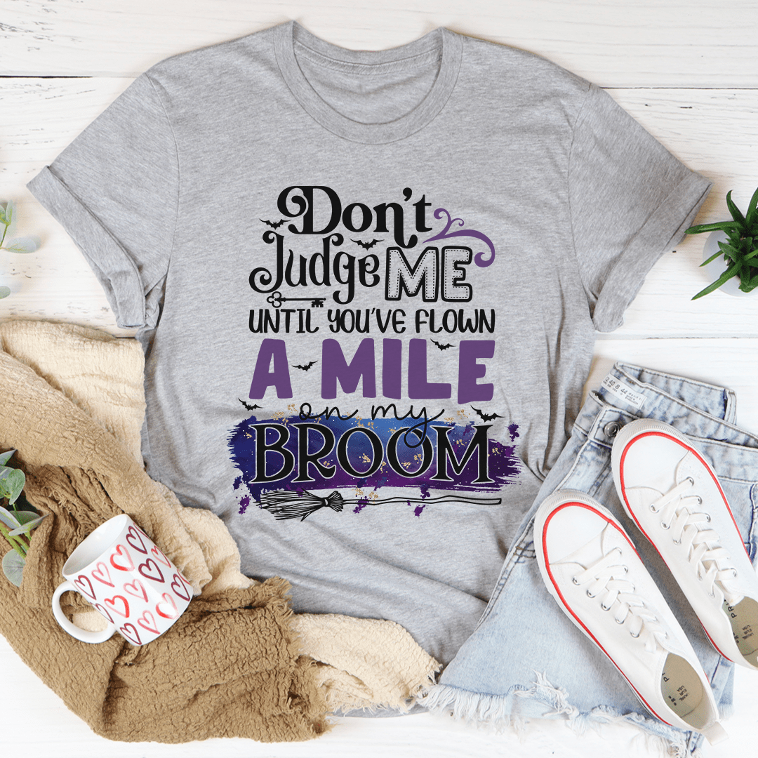 Dark gray T-shirt with “Don’t Judge Me” broom graphic in purple and black