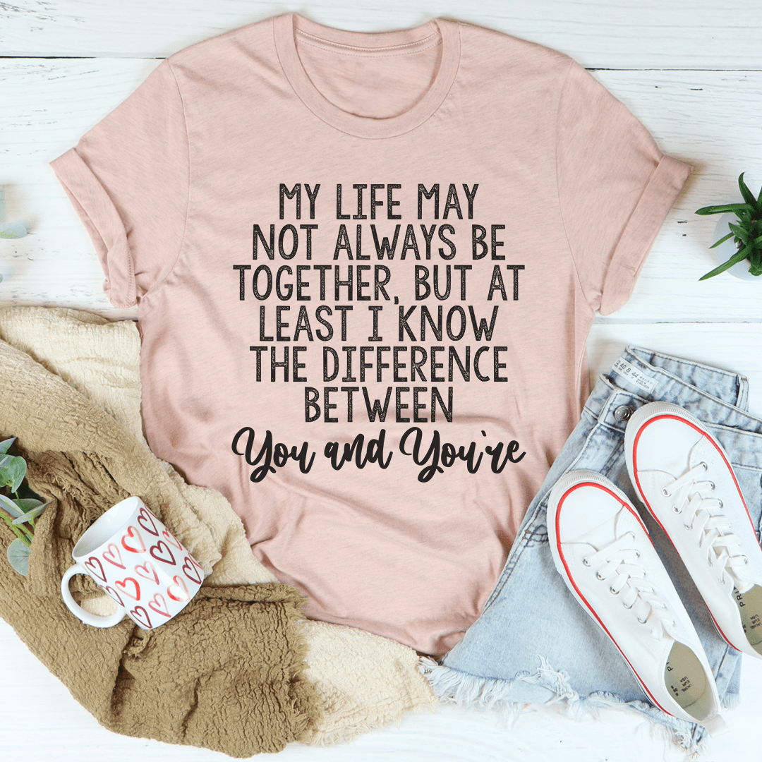 Light mauve T-shirt with quote graphic: “My life may not always be together, but at least I know”