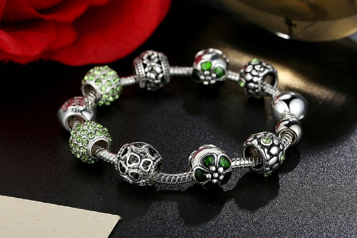 Green flower charm bracelet with silver-tone beads and heart Love centerpiece.