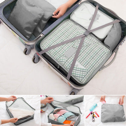 Gray and white packing cubes inside an open rolling suitcase with straps
