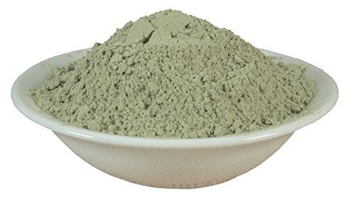 Green bentonite clay face mask powder in shallow dish