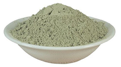 Green bentonite clay face mask powder in shallow dish