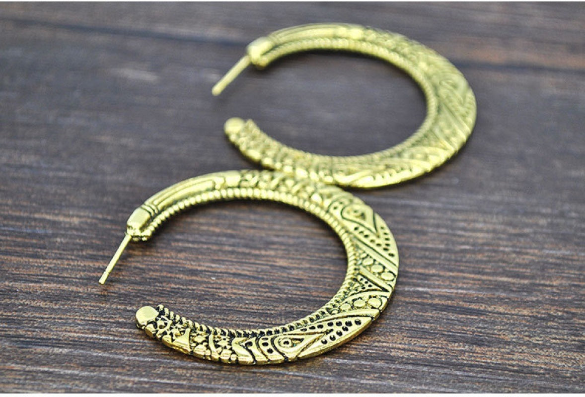 Gold-tone hoop earrings with engraved crescent pattern and straight stud posts