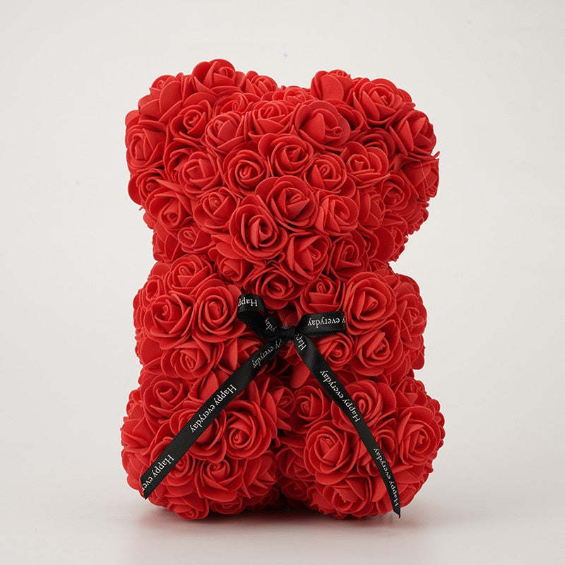 Red rose teddy bear with layered rosettes and a black bow ribbon on the front
