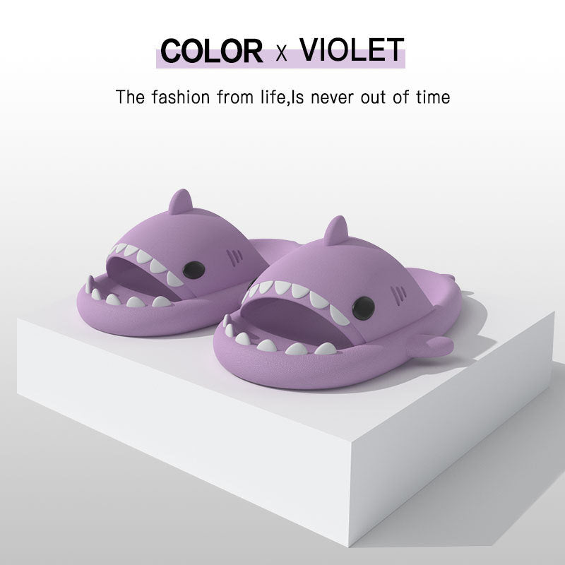 Purple shark-shaped slide sandals with molded white teeth and dorsal fin.
