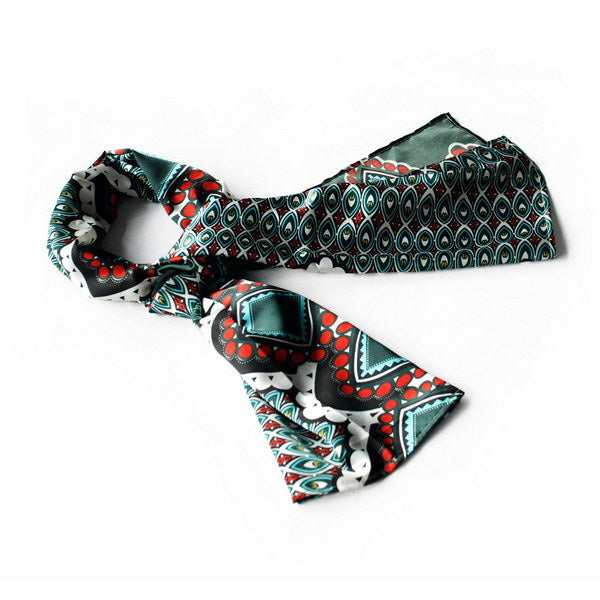 Dark green printed scarf with red and teal geometric patterns, rolled ends