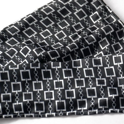 Silky black fabric close-up with white square chain motif