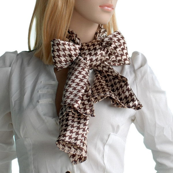 Silk scarf in brown and cream houndstooth plover pattern, tied at the neck