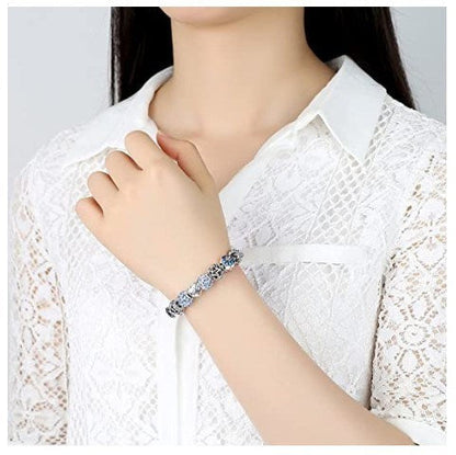 Silver-tone charm bracelet with blue sparkle beads and heart Love charm on wrist.