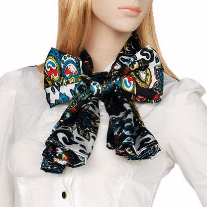 Paisley silk scarf worn with gathered knot at collar, teal and multicolor pattern