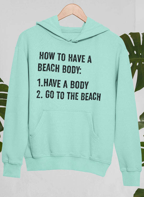 Mint green hoodie with front pocket and graphic text: “How to Have a Beach Body”