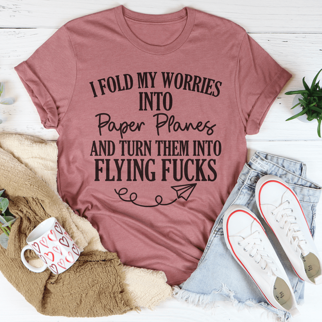 Mauve crewneck T-shirt front text: “I fold my worries into paper planes …” with flying-fucks text
