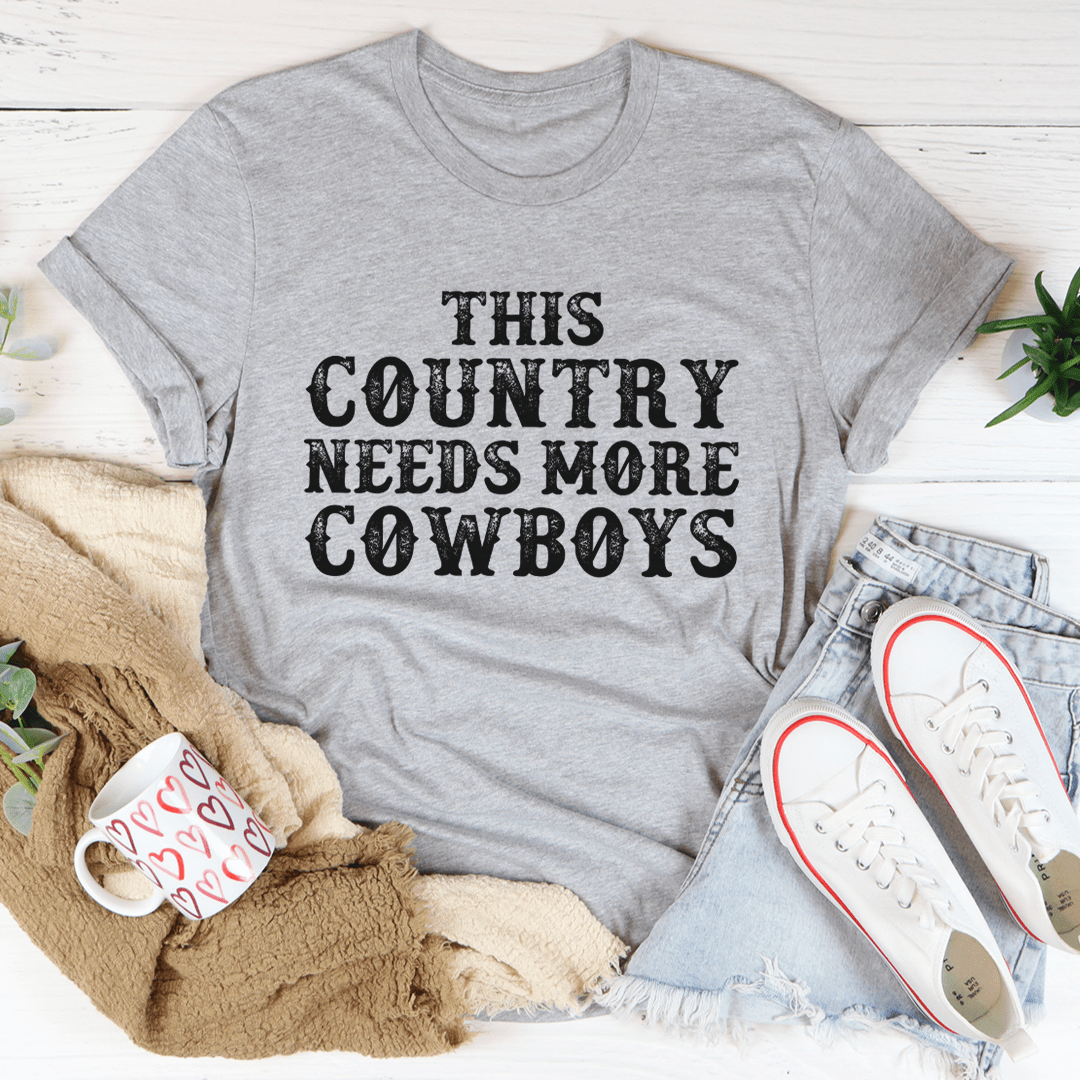 Athletic heather gray T-shirt with 'THIS COUNTRY NEEDS MORE COWBOYS' graphic