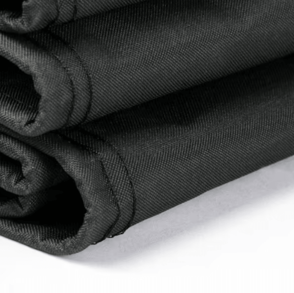 Rolled black fabric fire pit cover with stitched edge and drawstring channel