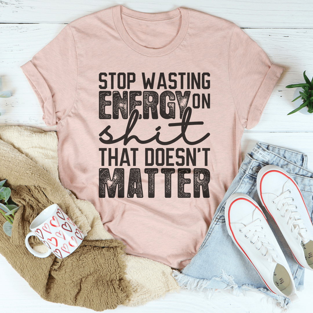 Mauve graphic t-shirt with bold stop wasting energy text and slogan front print