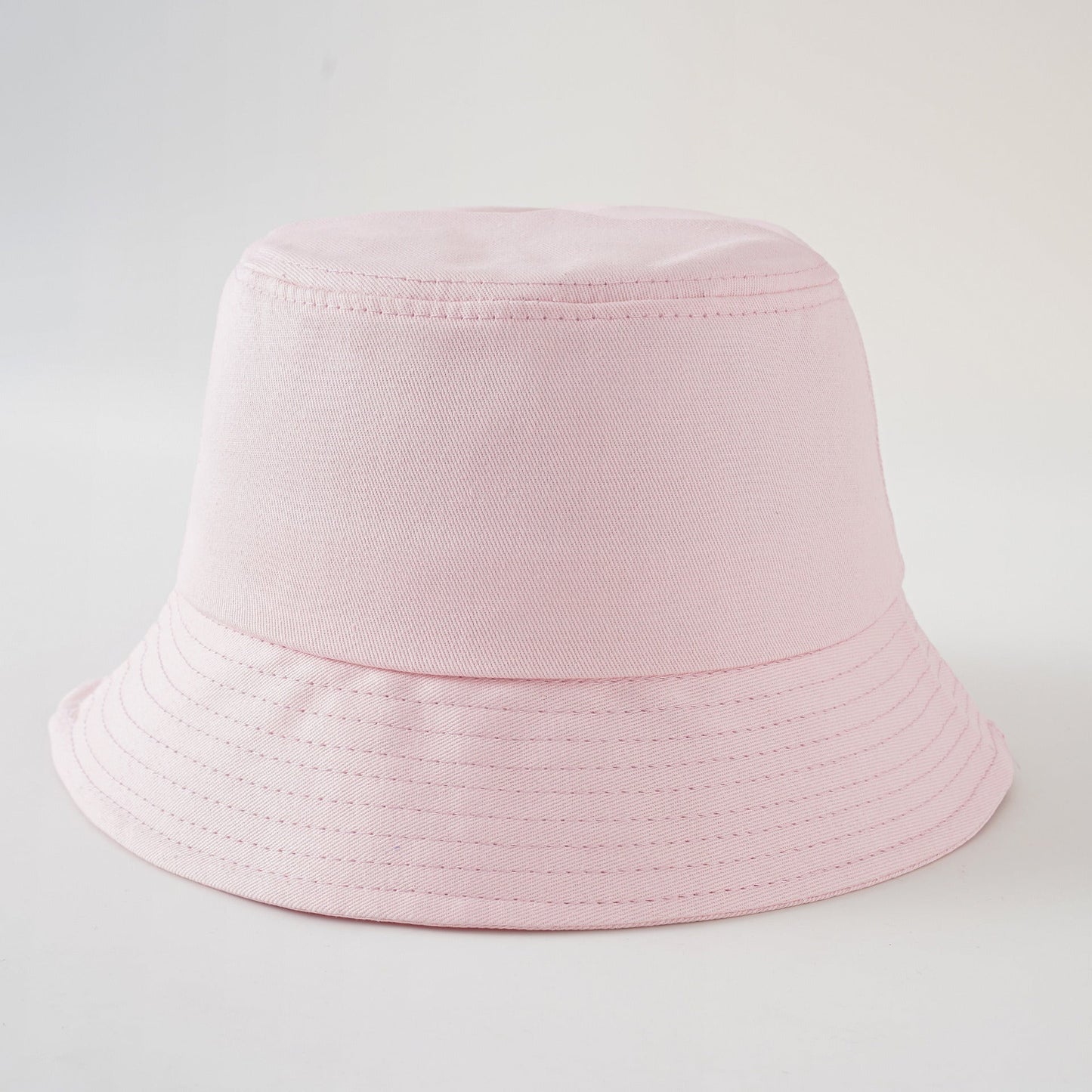 Light pink fisherman hat with short brim and stitched band, simple solid color