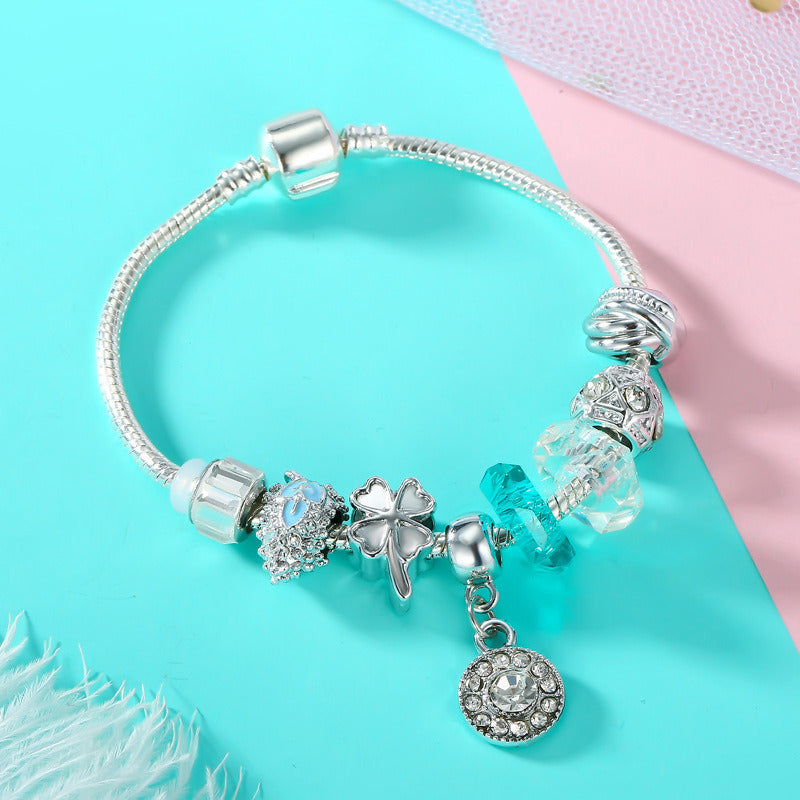 Silver charm bracelet with blue and clear beads, angel and round heart drop charm