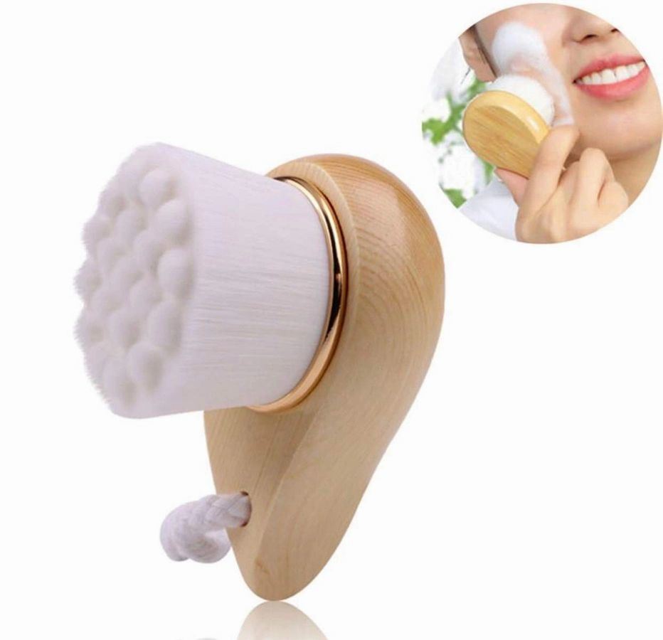 Facial brush with bamboo handle brushing a cheek with a soft white head.