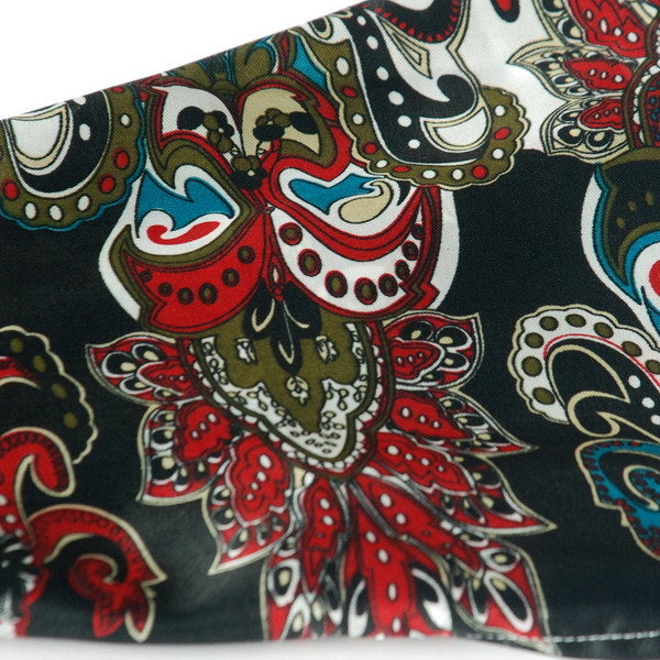 Close-up paisley scarf fabric in black with red, white, teal-blue details