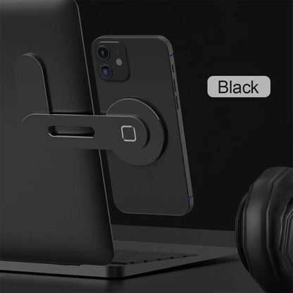 Black magnetic phone holder with circular base attached to a laptop