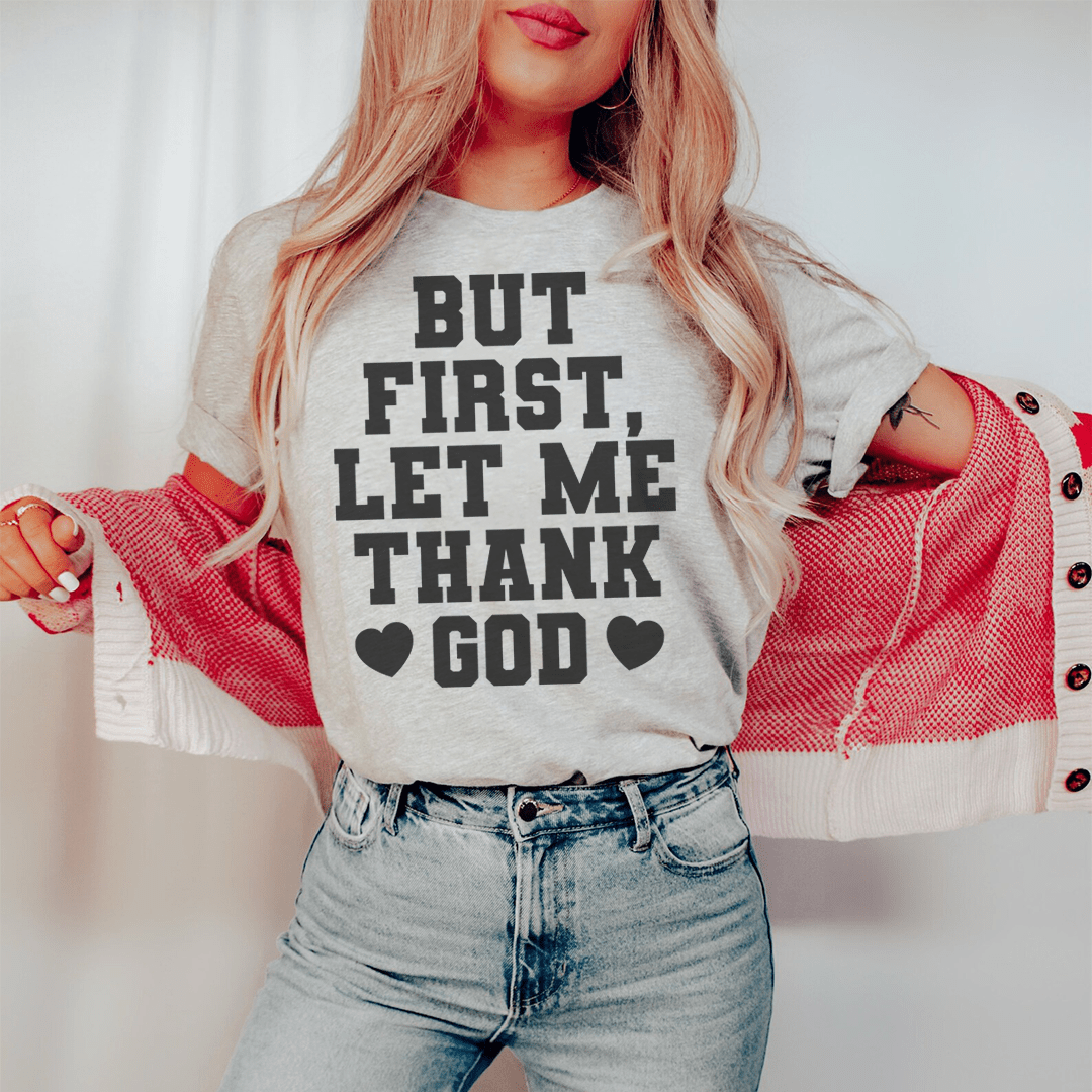 Gray T-shirt with black "But First, Let Me Thank God" block lettering and hearts