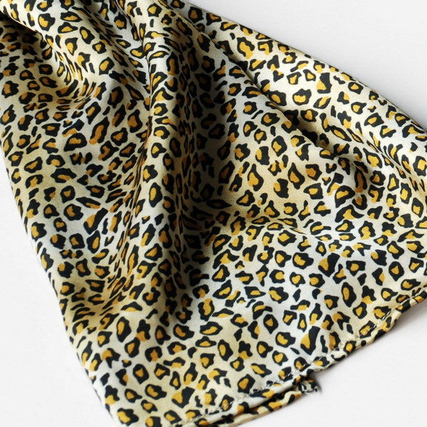 Leopard print scarf fabric with airy drape, tan base with dark brown spots