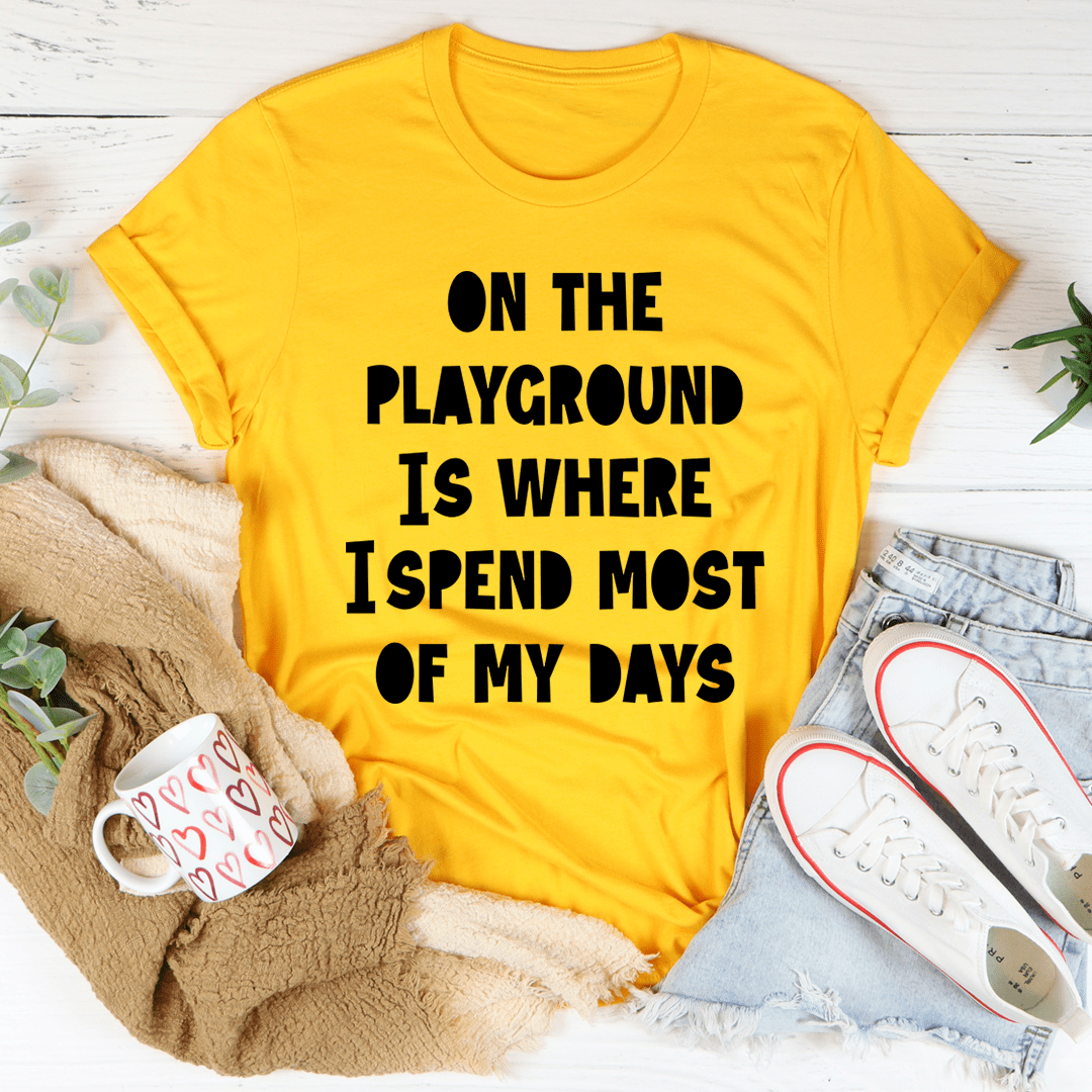 Mustard yellow short-sleeve T-shirt with bold black "ON THE PLAYGROUND IS WHERE I SPEND MOST"