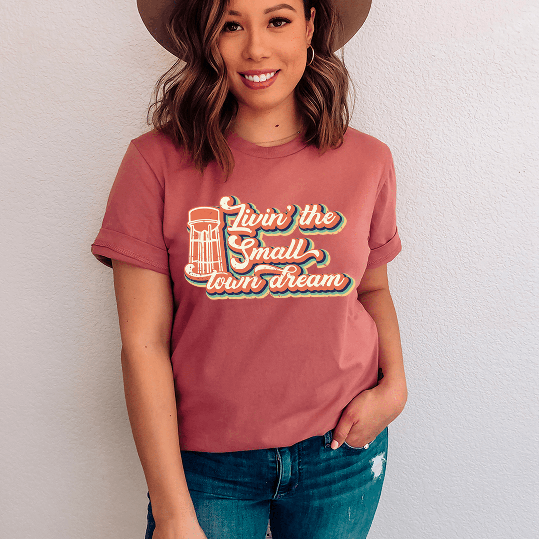 Mauve crewneck T-shirt with colorful lighthouse town dream graphic