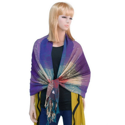 Pashmina scarf on model, purple center with multicolor woven border and fringe tassels.