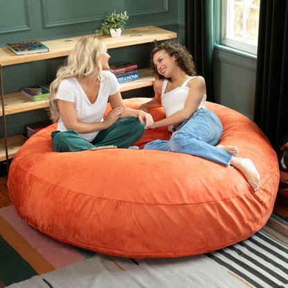 Mandarin orange cocoon bean bag chair for lounging with seam details around top