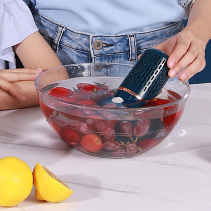 Ultrasonic produce cleaner in a glass bowl of mixed berries held by hands