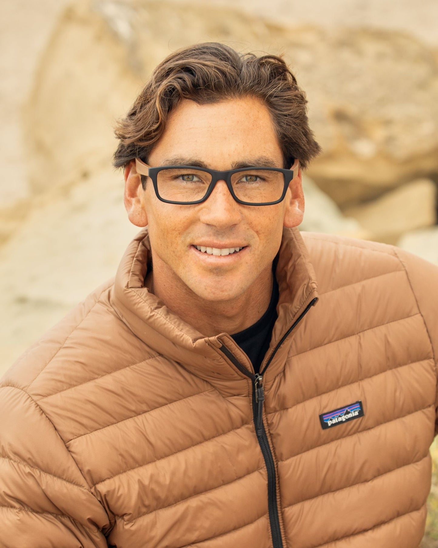 Blue light reading glasses on a smiling man with dark square frames