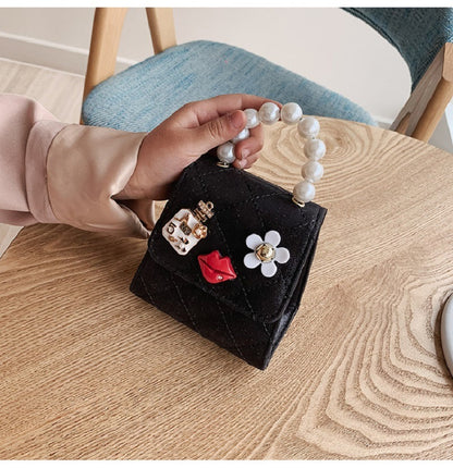 Kids mini crossbody bag in black with quilted texture, pearl handle, gold chain strap