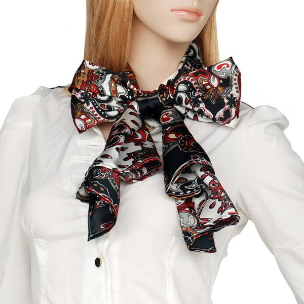Paisley scarf neck tie with black background, red and white scroll patterns.