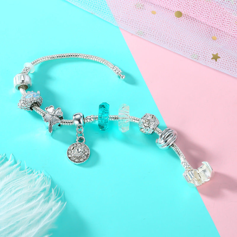 Silver charm bracelet with blue and clear beads, angel charm and round heart drop
