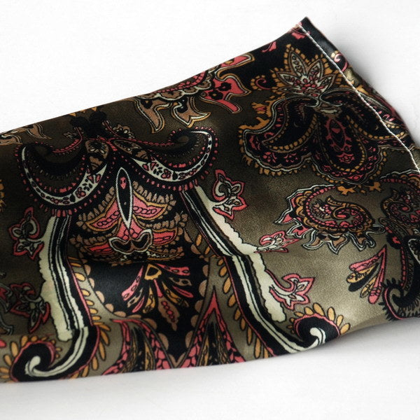 Paisley silk scarf close-up, dark base with pink, gold, and olive ornate designs