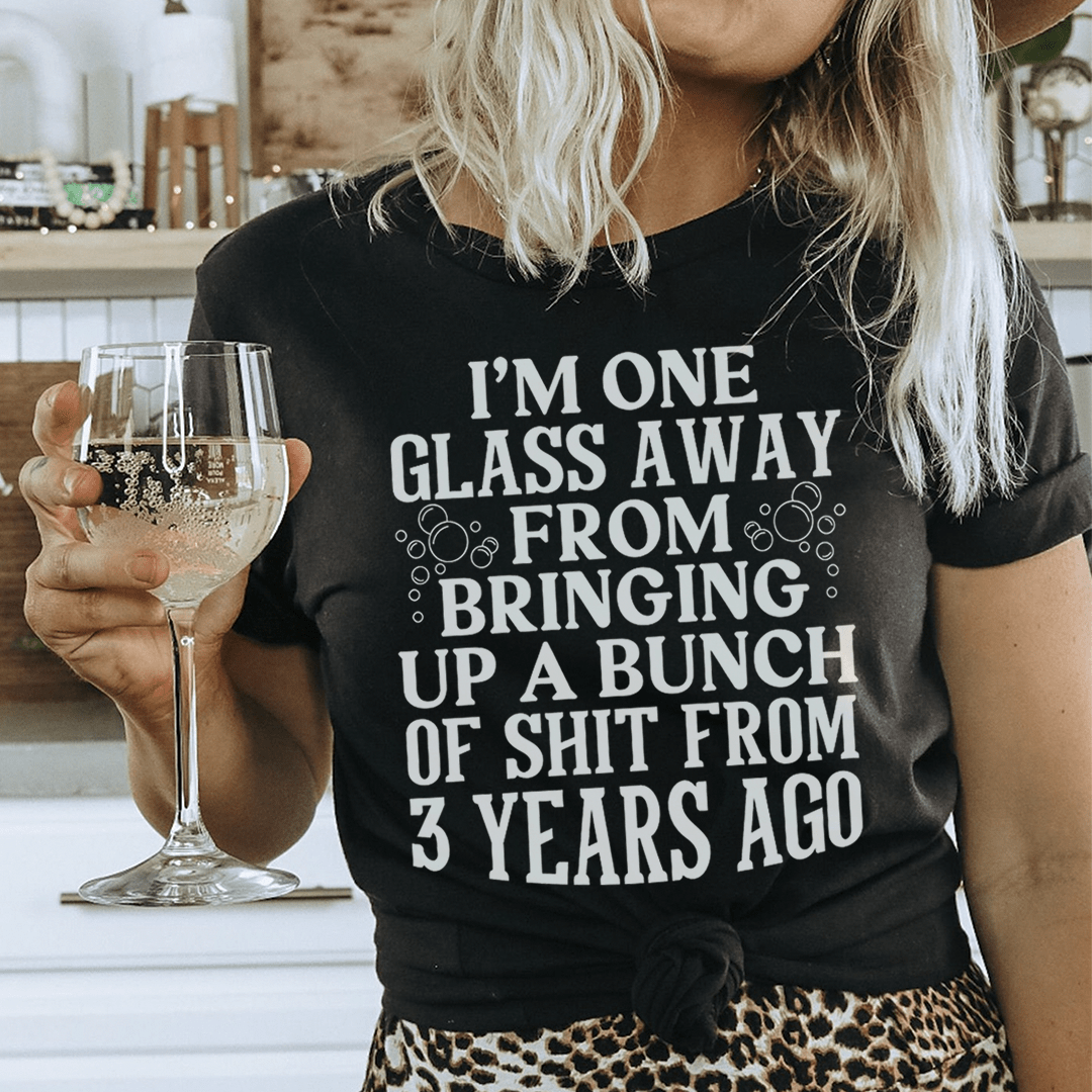 Black graphic T-shirt worn by model, 'I'm one glass away' slogan printed on chest