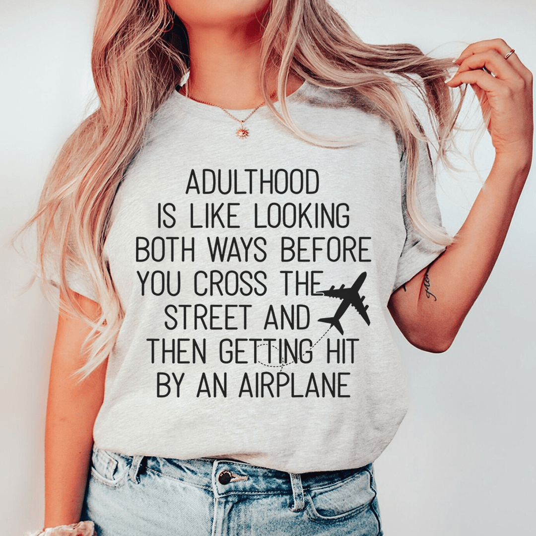 Light gray crewneck T-shirt worn by model with front slogan and airplane graphic