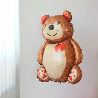 Brown bear foil balloon with red heart on white belly; strings hanging