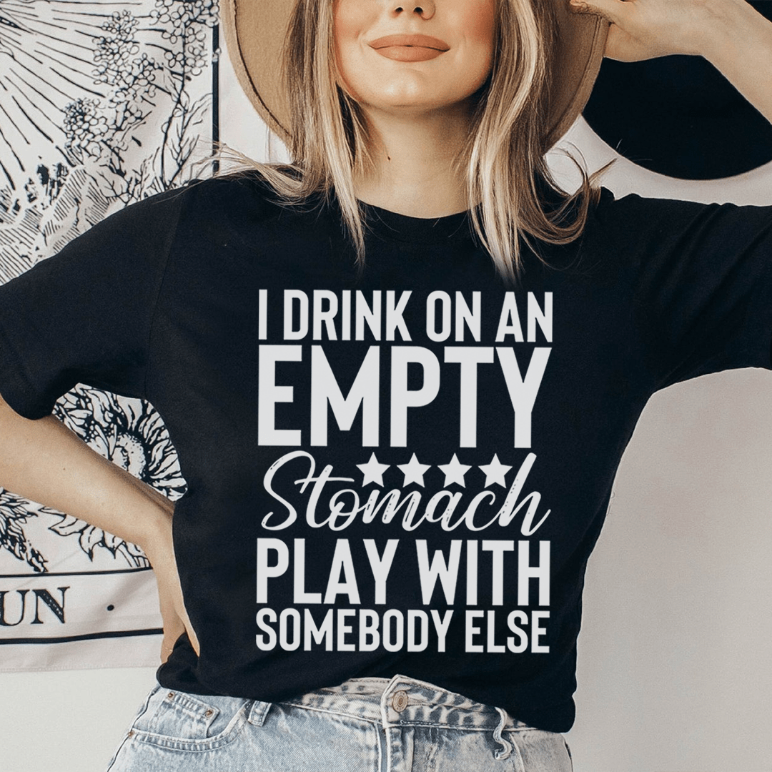 Black t-shirt with large stacked text slogan in white and gray: "EMPTY Stomach PLAY..."