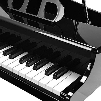 Black toy piano keyboard close-up with white keys and black buttons