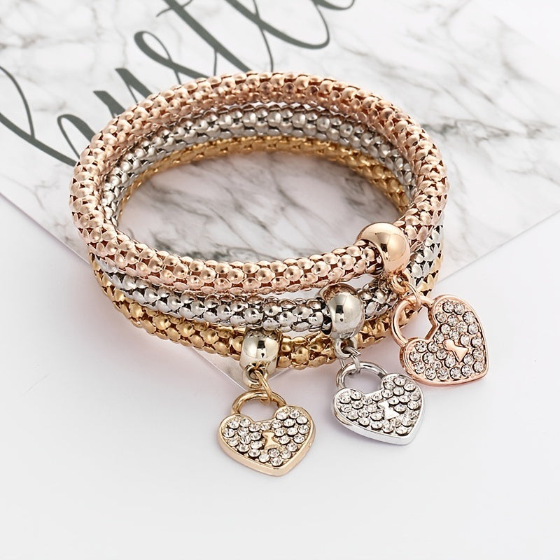 Three-row rhinestone heart charm bracelet with round clasp and four dangling hearts