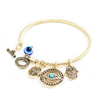 Twisted charm bracelet with evil eye and hamsa charms, blue enamel accents, gold-tone finish.