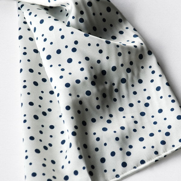 White silk scarf fabric with scattered small black and navy dot pattern