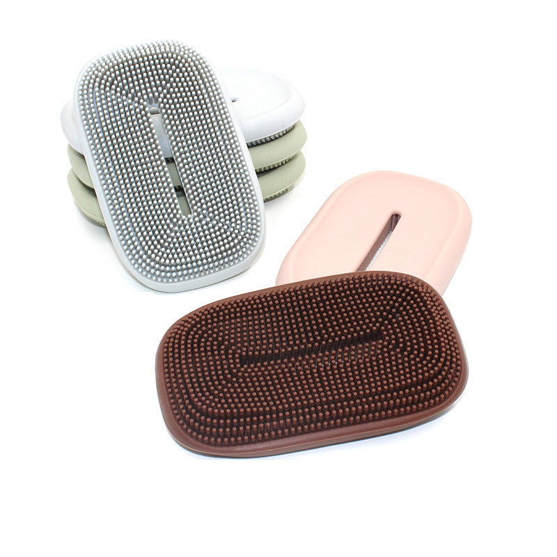 Soap holder with textured silicone brush pad and pink soap dish base, side view.