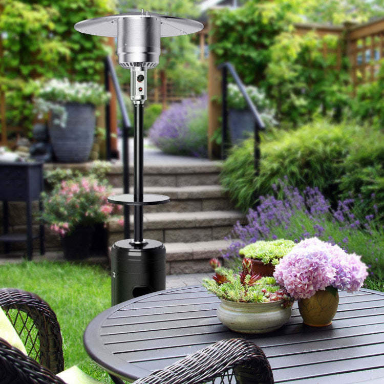 Black propane patio heater with round tabletop and glowing burner in garden setting