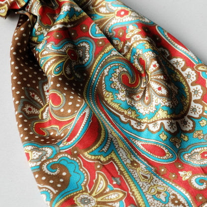 Silk scarf close-up with teal paisley swirls, red accents, and white highlights on dots