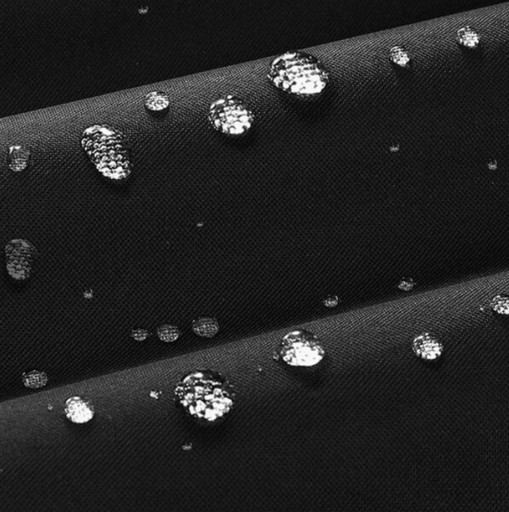 Black fabric fire pit cover with water droplets on the surface