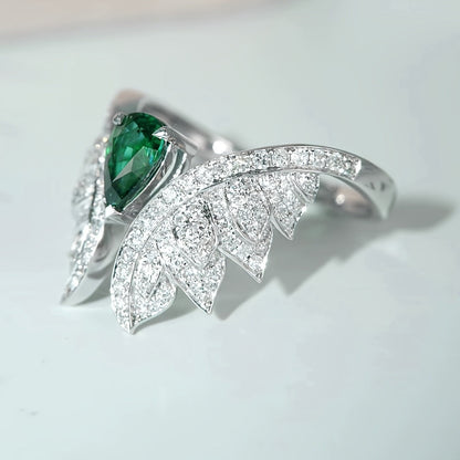 Silver zircon wing cluster ring with green oval center stone and pavé bands