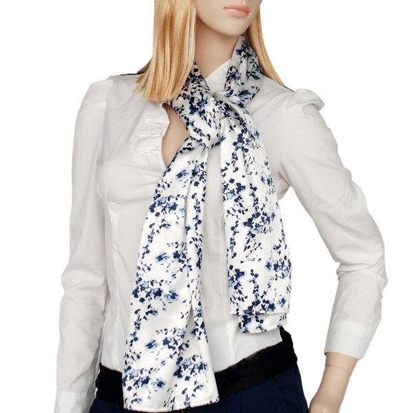 White scarf with navy floral pattern, worn with a bow at the neck